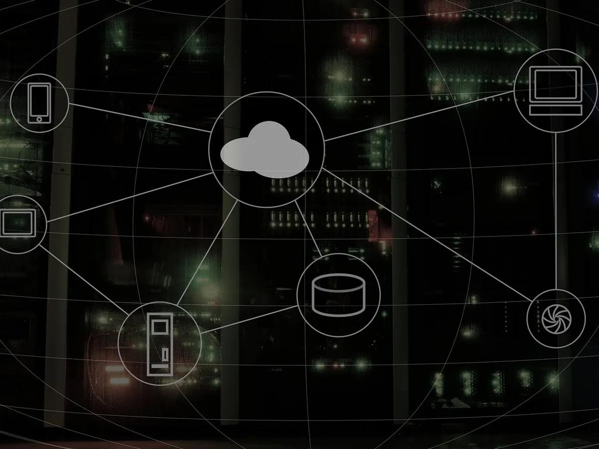 Line icons of a cloud, a database, phones and computers joined in a network over a dark server room.